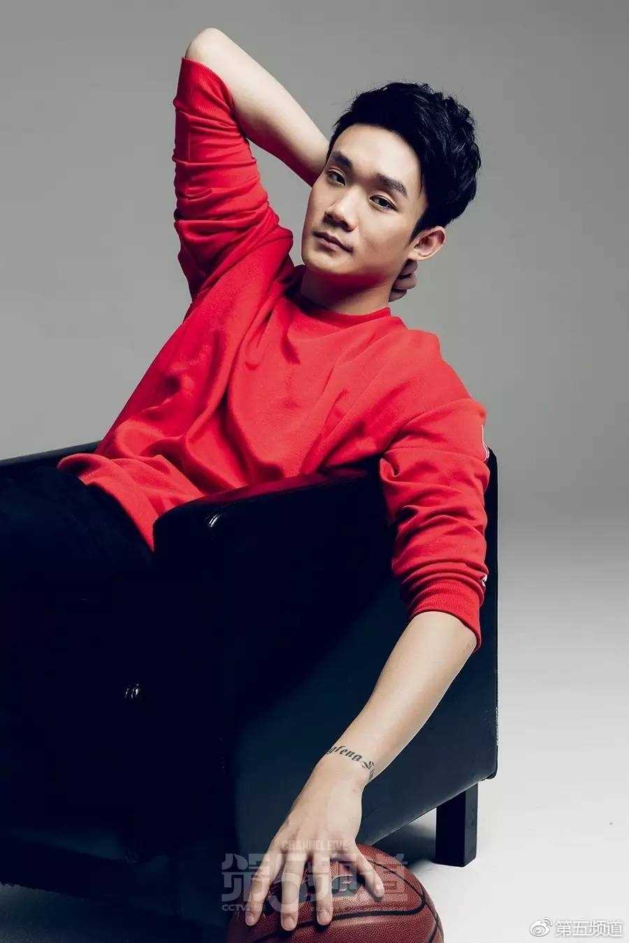 丁彦雨航单手托腮陷入沉思，格子衬衫搭配休闲裤的造型显得书卷气十足，仿佛在思考着篮球哲学或是对未来的无限憧憬。