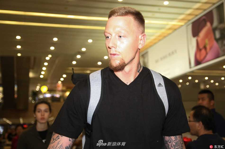 在机场休息区，明纳拉斯与妻子相对而坐，两人脸上都带着轻松愉悦的表情，仿佛在讨论着即将在上海展开的新生活，画面宁静而美好