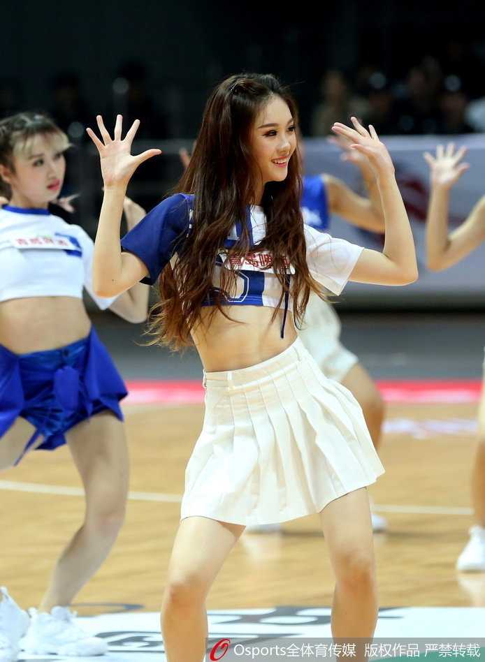严寒中的热舞精灵:致敬八一男篮赛场上的篮球宝贝 舞台中央,篮球宝贝们梳着利落的马尾,身着红白相间的性感短裙,随着动感音乐整齐地跃起,修长的身姿在灯光下划出优美的弧线,笑容比聚光灯还要灿烂。