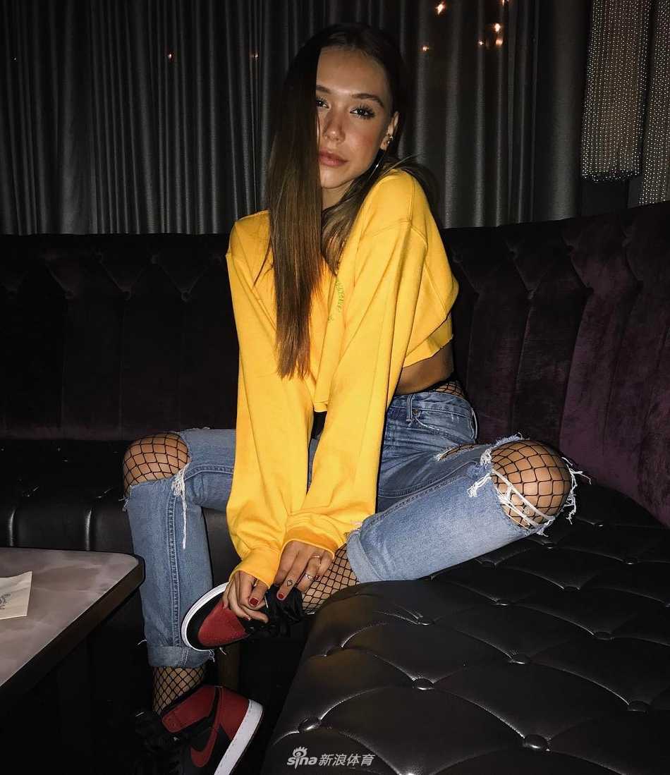 中美「球鞋女神」颜值美腿大比拼:当加州阳光邂逅东方舞韵 Alexis Ren身处洛杉矶的街头涂鸦墙前,她穿着高腰牛仔裤,上身是一件简约的白色Crop Top,露出紧实的马甲线,脚上的亮色AJ成为全身穿搭的焦点,尽显美式街头的随性与自信。