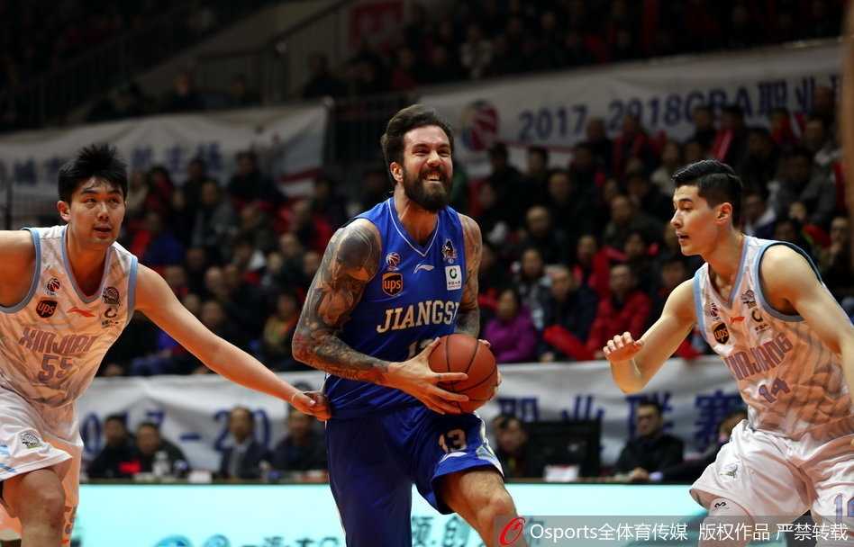 新疆队亚当斯在江苏队严密防守下依然自信出手，篮球在空中划出优美弧线