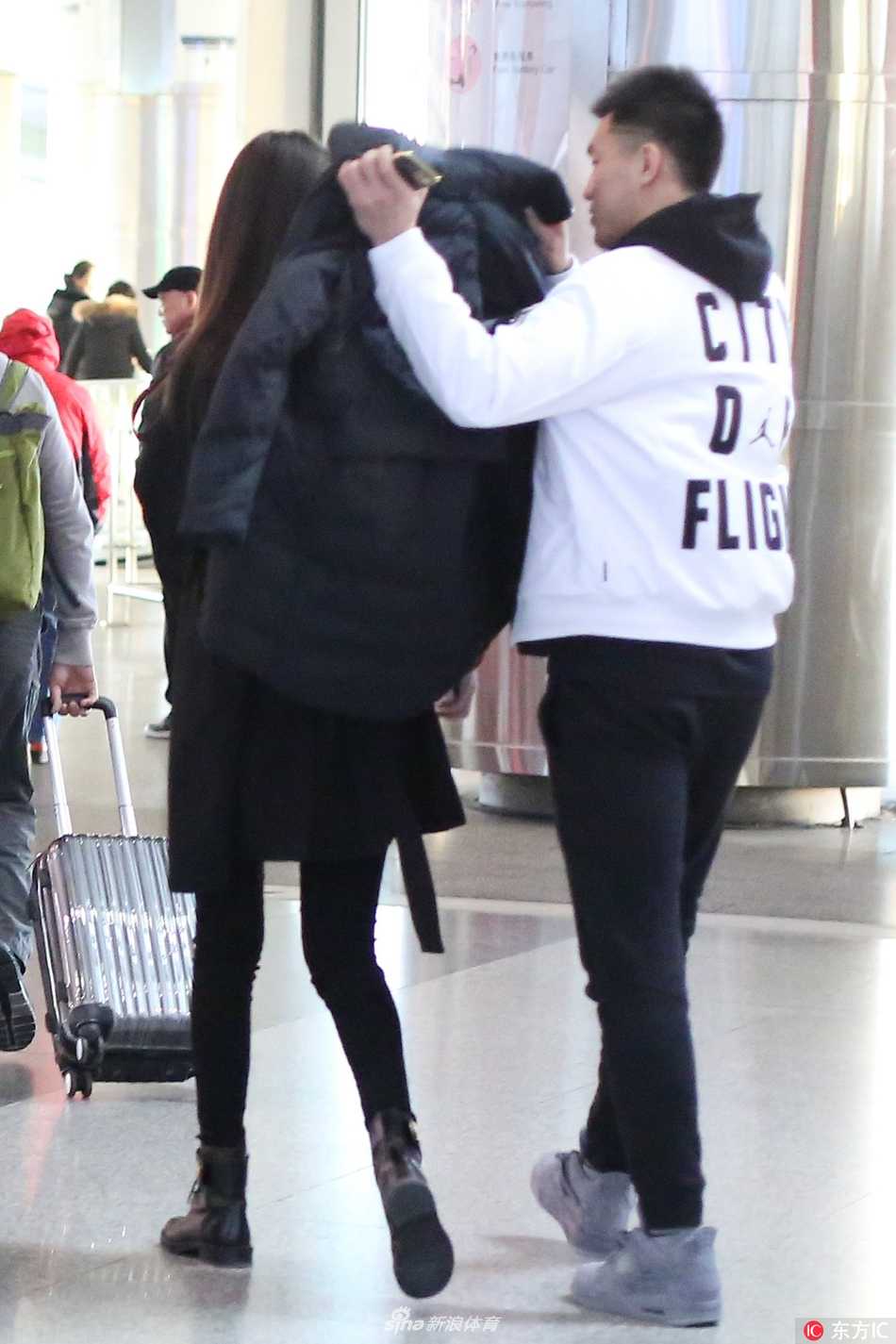 京城冬夜的一抹暖意:郭艾伦机场接机演绎铁汉柔情 郭艾伦身着休闲装,安静守候在机场到达大厅,手中紧握着一杯刚买好的热咖啡,目光穿过人群,专注地寻找着熟悉的身影,脸上洋溢着期待的微笑。