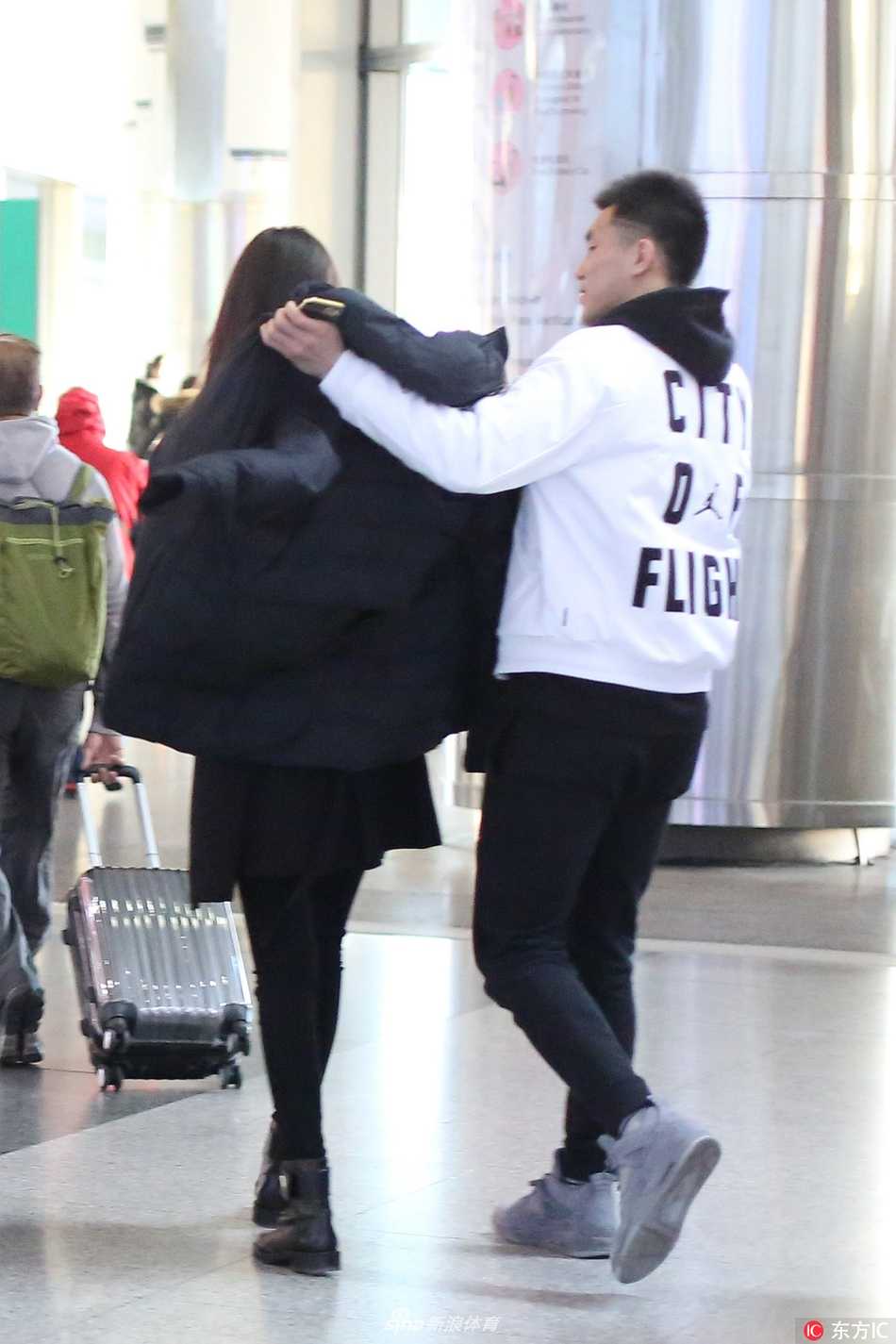 京城冬夜的一抹暖意:郭艾伦机场接机演绎铁汉柔情 两人在机场大厅中缓慢前行,郭艾伦手中依然拿着东西,时刻关注着女友的步伐,即使只是一个背影,也能让人感受到那份无微不至的照顾与陪伴。