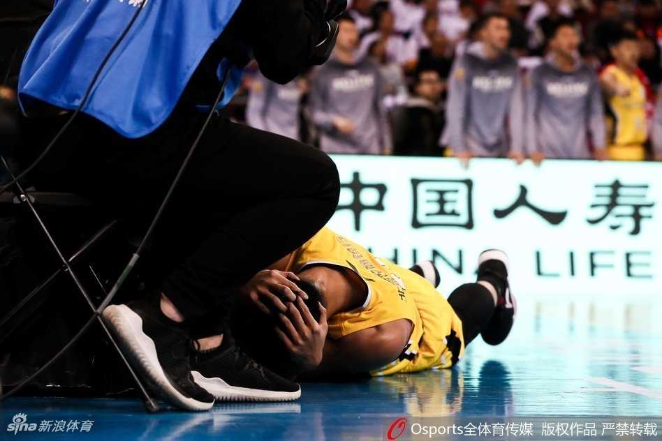 突破上篮后的贺希宁重摔倒地，表情痛苦地蜷缩在底线附近，常林从他身边跨过准备发球。