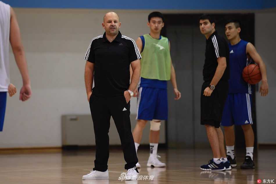 京城篮球新篇章:雅尼斯挂帅,首钢男篮步入团队篮球时代 在一次战术演练中,雅尼斯召集队员们围成一圈,他用夸张的肢体动作讲解着跑位路线,队员们聚精会神地聆听,光头主帅与球员们的神情在阳光下格外专注。