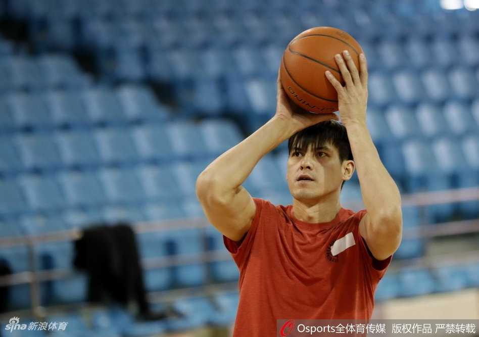 主教练张庆鹏手持战术板，神情专注地向球员们讲解跑位细节，手势坚定有力，传递着他的战术理念与临场指挥智慧。