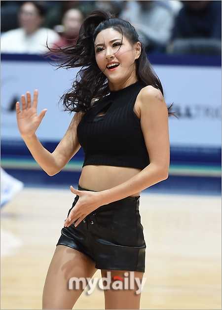 仁川体育馆热力四射,篮球宝贝皮短裤劲舞成赛场靓丽风景 镜头拉近,捕捉到一位队员自信从容的面部表情,她手持花球,即使在高强度的舞蹈中依然保持着迷人的微笑,皮短裤的帅气与女孩的柔美在她身上完美融合