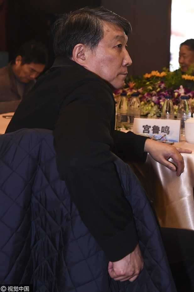 在发布会后台，宫鲁鸣与老朋友苏群相遇，两人双手紧握，面带笑容地交谈，宫指导的眼神中透露出对新工作的期待与坚定。