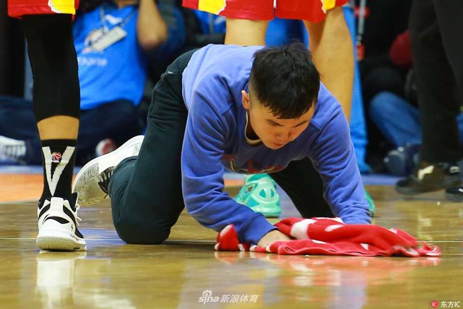 从少林武僧到CBA名人堂擦地工:孟飞的极速人生 镜头聚焦在孟飞刚擦拭过的地板上,那片区域光亮如镜,反射着球馆顶部的灯光,与周围略显暗哑的木地板形成鲜明对比,见证着他极致工作的成果。