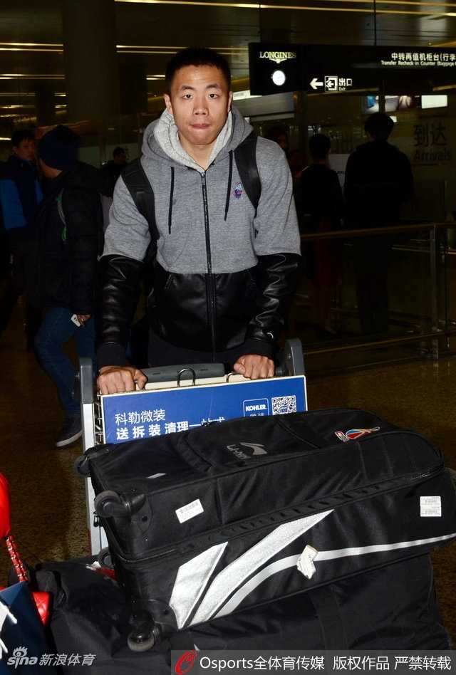 上海队另一位外援明纳拉斯同样被球迷簇拥，他高大的身材在人群中格外醒目，正亲切地与一名小球迷进行互动。