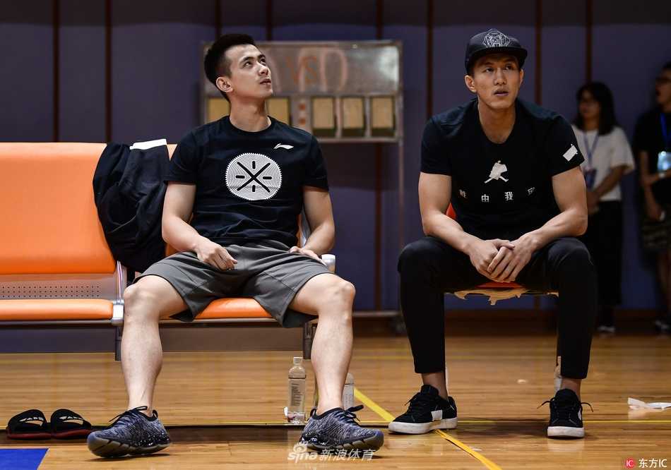 伤病侵袭下的辽篮双子星:郭艾伦与赵继伟场边观战,目睹球队季前赛惜败浙江 郭艾伦神情专注地坐在场边,身着便装观看着场内激烈的比赛,眼神中透露出对赛场的渴望