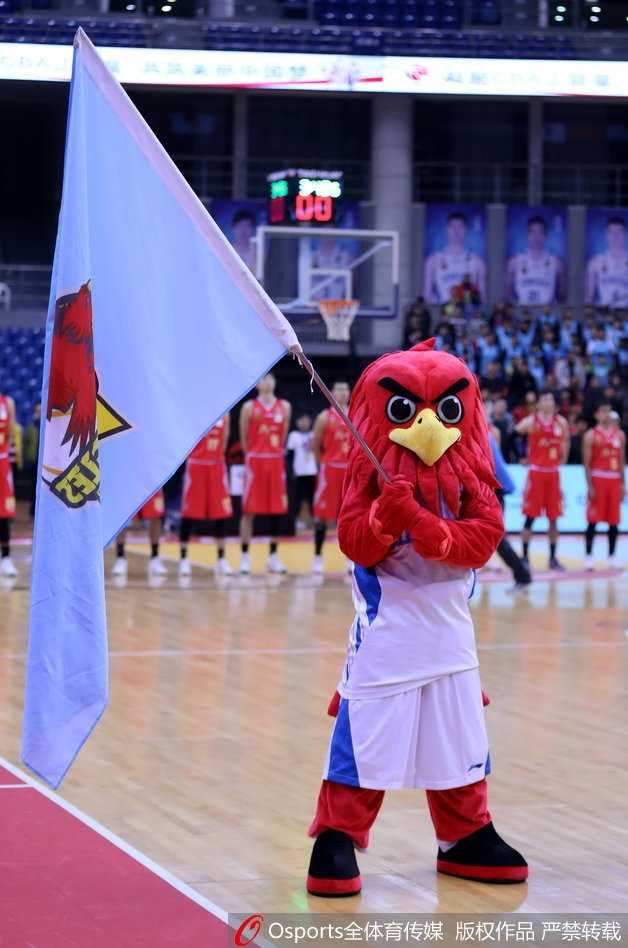 光影之外的舞者:青岛啦啦队与她们的CBA赛场故事 青岛啦啦队宝贝在场边稍作休息,她低头查看手机,金色的亮片上衣在灯光下闪烁,与场上紧张激烈的比赛形成有趣对比,展现了赛场花旦在动与静之间的瞬间转换。