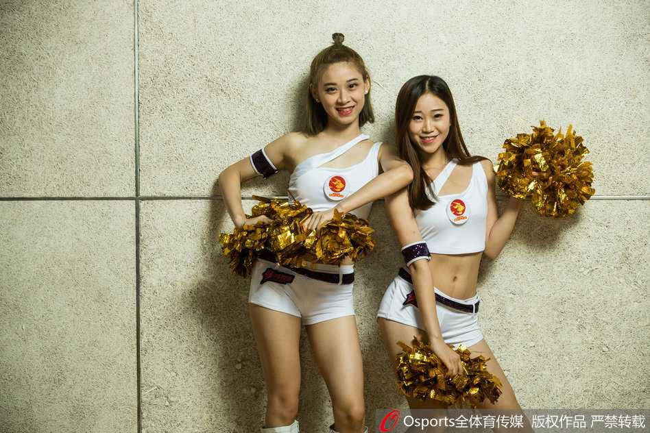 光影律动·助威新篇:聚焦赛场边的动人风景 两位篮球宝贝在赛前更衣室内对着镜子互相整理妆容,暖黄的灯光映照出她们认真而温柔的侧脸,幕后准备同样动人