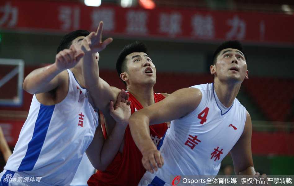 全运赛场展军威:邹雨宸率解放军队狂胜吉林,姚明现身引瞩目 解放军内线核心邹雨宸在吉林队多名球员的包围下,高高跃起,用强壮的手臂将篮板球牢牢控制在手中,眼神中充满了对胜利的渴望。