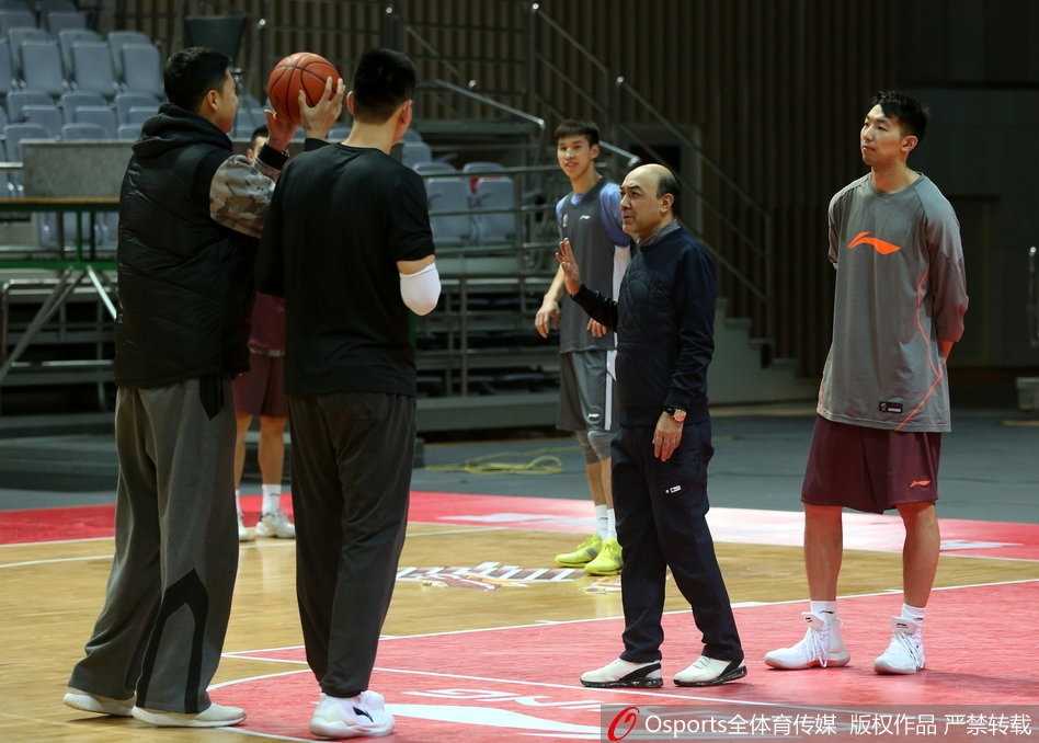 八一连夜备战京城德比 王治郅尤纳斯场边追忆08奥运峥嵘 八一队年轻内线球员在篮下进行对抗训练,表情坚毅,肌肉线条在汗水浸润下闪闪发光,王治郅在一旁双手叉腰,目光如炬地注视着每一次起跳和出手,准备随时上前指导。