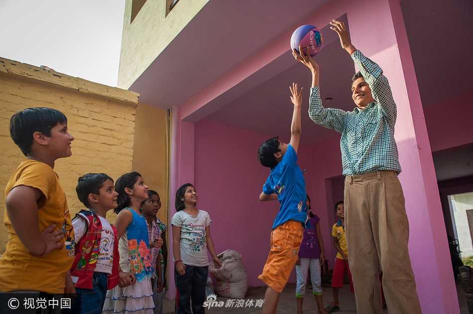 母子球场上的传承：身材高大的母亲正弯腰指导卡兰打篮球，两人穿着同样的球衣和鞋子，这个温馨的场景不仅是母子间的互动，更是篮球梦想的代际传递，仿佛能看到未来球场明星的影子。