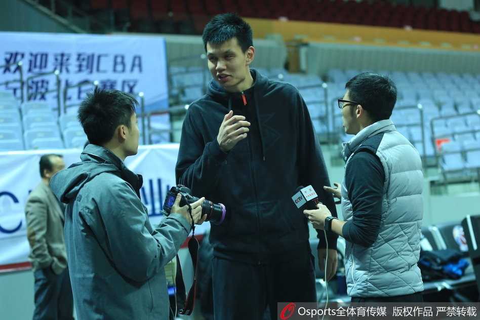 军旅传承:许钟豪变身记者对话大郅,八一队逆境中寻光 全体队员围成圆圈,将王治郅簇拥在中间,大家拳头碰在一起,齐声高喊加油,许钟豪站在大郅身旁,手臂高举,脸上洋溢着团队凝聚力的坚毅。