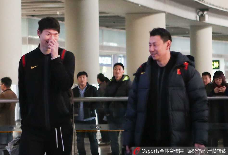 凯旋归来话征程:李楠王哲林谈笑风生背后的男篮红队新气象 李楠指导身着国家队运动外套,面带微笑地推着行李车,眼神中透露出对弟子们的肯定与未来的期许。