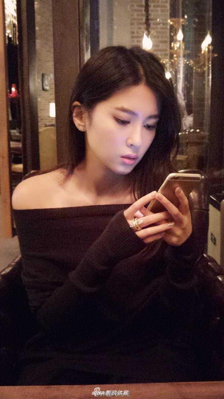 刘晓宇与钟鹿纯:篮坛金童玉女的浪漫情缘 钟鹿纯身穿黑色露肩连衣裙,展现出迷人的锁骨和香肩,面对镜头露出甜美自信的微笑,气质高贵而迷人。