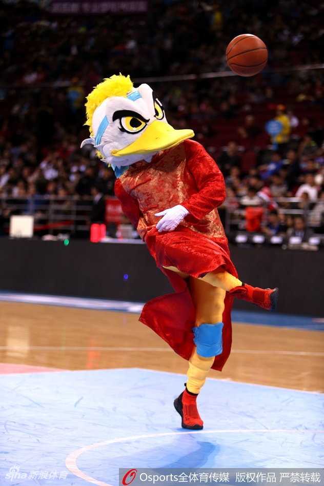 北京篮球圣地春节红 霹雳鸭盛装助力首钢挺进季后赛 霹雳鸭换上了金光闪闪的状元服,头戴官帽,手里拿着一个巨大的拨浪鼓,摇头晃脑地在球员通道口迎接即将登场的首钢将士们。