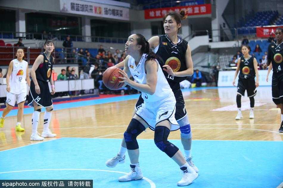 山东女篮队员在严密防守下强行突破上篮，北京队两名球员高高跃起进行干扰，比赛对抗激烈，瞬间火花四溅