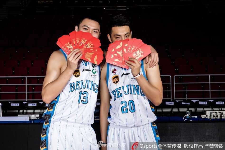 北京首钢新春献瑞 光影之间书写篮球豪情 段江鹏和朱彦西并肩而立,背景是虚化的红灯笼,两人目光坚毅地望向远方,身上那股属于狙击手的冷峻与精准,在节日的红火中依然醒目。