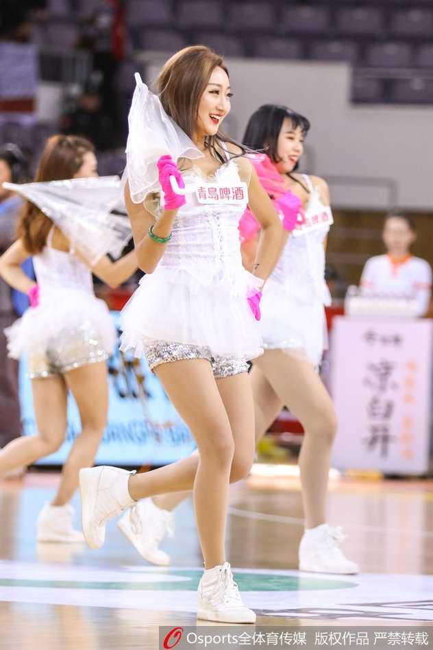 北控篮球宝贝:寒冬里的热舞,赛场边最靓丽的风景线 一名篮球宝贝的特写镜头,她微侧着头,眼神中带着一丝俏皮与妩媚,精致的妆容在球场灯光下显得格外动人,展现了新生代啦啦队员的青春风采。