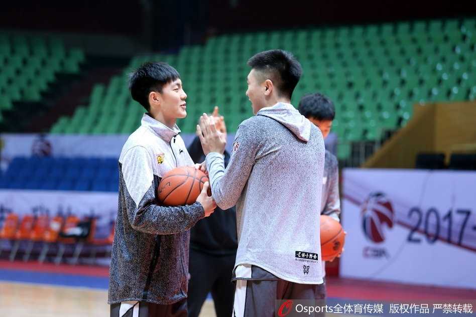 华南虎厉兵秣马迎恶战 易建联挥汗如雨扛重任 训练进入尾声,易建联赤裸着上身,露出健硕的肌肉线条,他弯腰捡起地上的训练服,准备离场。汗水浸湿了他的头发,折射出场馆内的灯光。