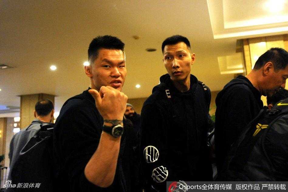 广东队长周鹏低头看着手机，神情专注，或许正在研究对手的战术，又或是在给家人报一声平安，大战前的平静写在他的脸上。