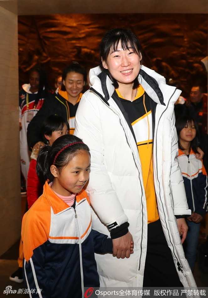 女篮姑娘们弯腰牵起山里娃的小手，阳光下的大手小手紧紧相握，温情在八一纪念馆的台阶前流淌。