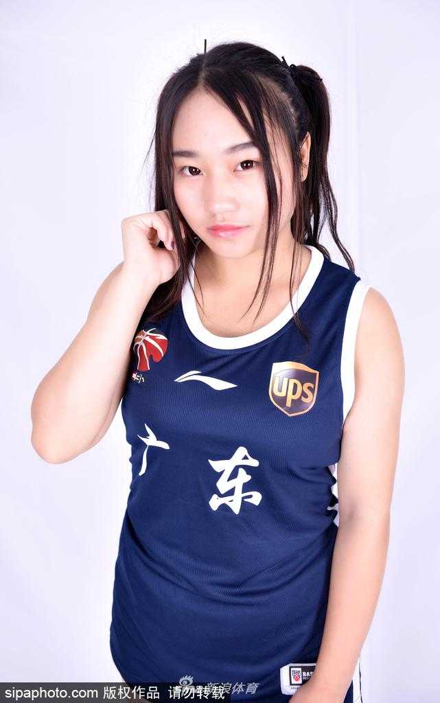 南粤热舞,倾力助威:广东男篮与他的篮球宝贝们 在温暖的逆光中,一位篮球宝贝的轮廓被勾勒出来,她正自信地撩动头发,画面充满艺术美感。