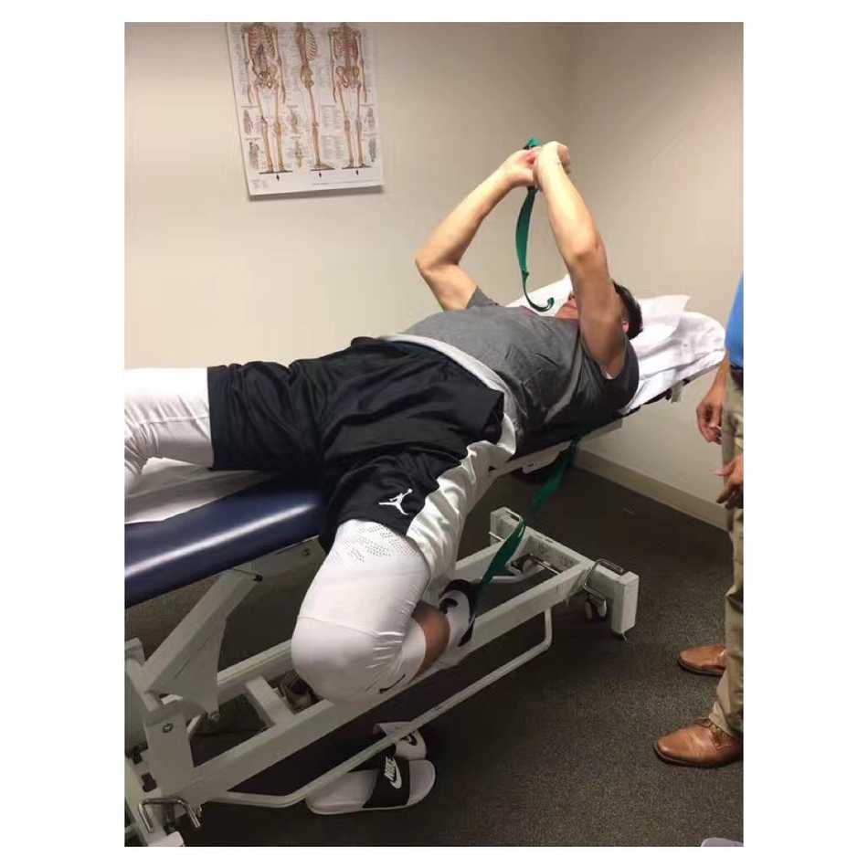 可兰白克远赴重洋疗膝伤 坚韧队长带药硬扛一载只为冠军梦 医生正在为可兰白克进行拉伸治疗,他紧咬牙关,小腿肌肉紧绷,虽然面容有些许痛苦,但依然全力配合着康复师的每一个动作。