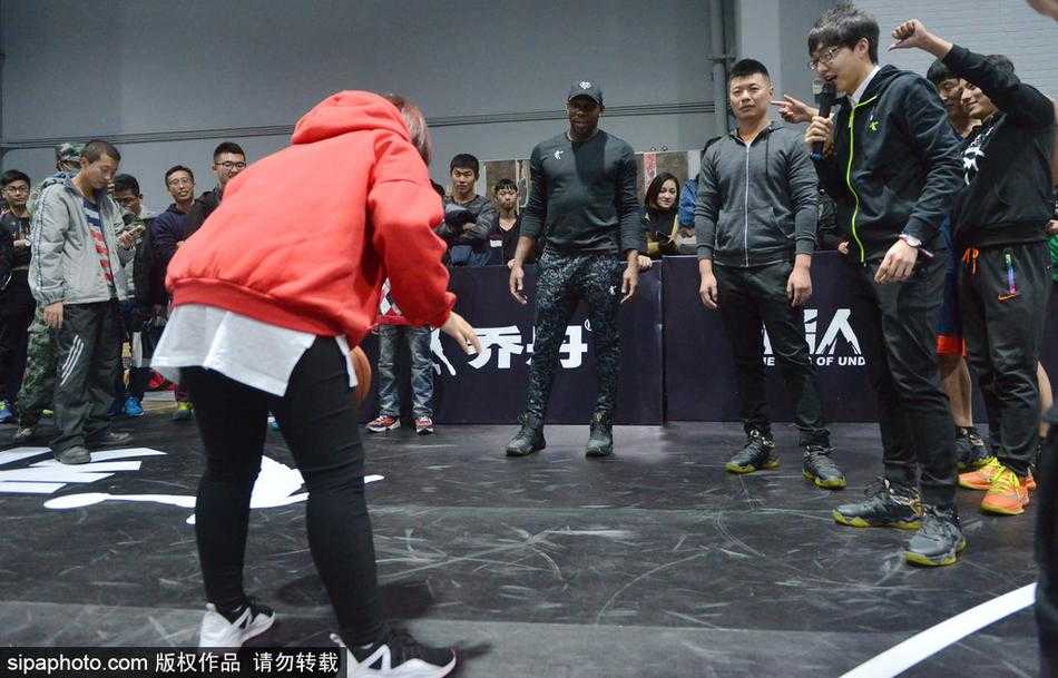 哈德森沈阳秀三分教女球迷运球 引爆篮球嘉年华 哈德森出手三分后眼神紧盯篮球轨迹,表情专注,背景里的沈阳球迷纷纷举起手机记录下这一瞬间。