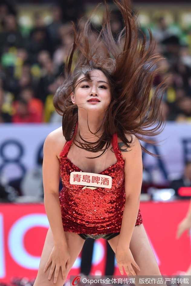 四川篮球宝贝热舞助威,金强主场迎战广厦气氛火爆 赛后篮球宝贝们在场上合影,高举手臂,庆祝又一次成功的表演,身后是退场的球迷。