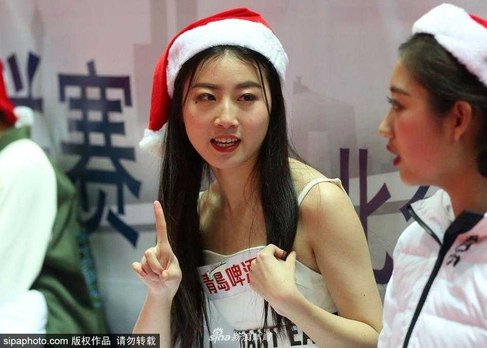 圣诞夜的雅戈尔体育馆:八一男篮背后的篮球宝贝与她们的场下瞬间 镜头转向另一侧,宝贝们围成一圈对着手机镜头比出可爱的剪刀手,背景是雅戈尔体育馆的看台和正在热身的八一队员,一张完美的打卡照就此诞生。