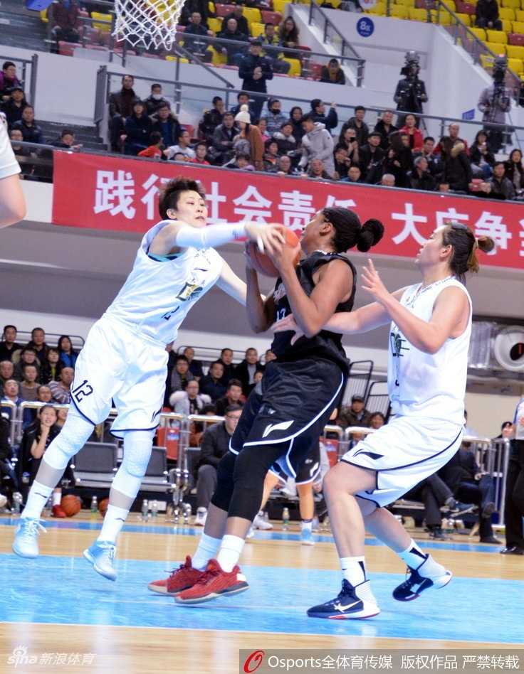 陕西队外援摩根-塔克遭遇大庆女篮的双人包夹，她在严防下依然奋力跃起，试图完成一次高难度的传球。