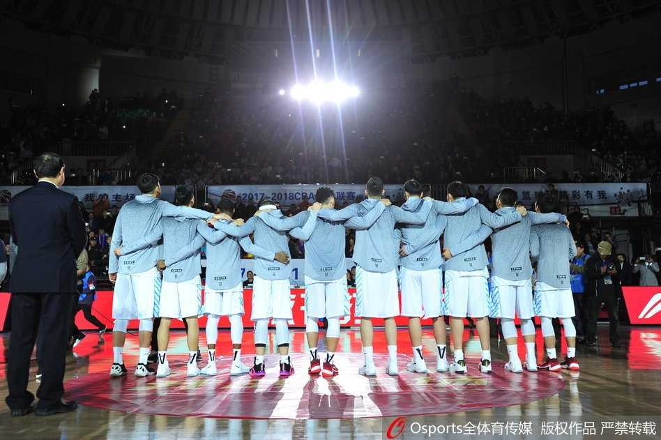 天山之巅荣耀传承 新疆男篮主场加冕总冠军戒指 新疆队全体成员在场地中央围成一圈,共同将手中的总冠军戒指朝向镜头,每个人的脸上都绽放出最灿烂的笑容,记录下这支冠军之师最完整、最荣耀的大家庭合影。