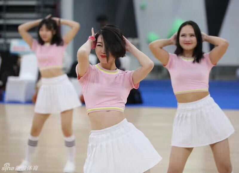 在健身房里，女孩举起手臂展现优美的肌肉线条，她穿着运动背心和短裤，健康的体魄和自信的神态诠释着运动之美。