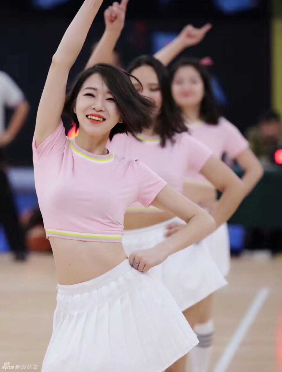 一位拥有精致五官和纤细腰肢的新疆女孩，穿着清凉的夏日装束，对着镜头自信地展示着她的好身材和活力。