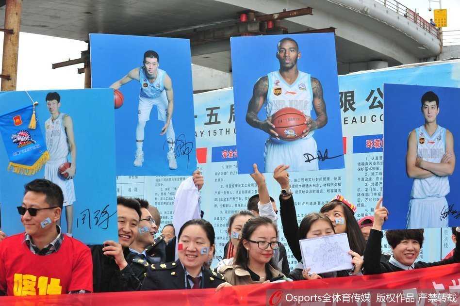 乌鲁木齐地窝堡机场航站楼内，人山人海，数千名身着新疆队球衣的球迷们高举着欢迎横幅和周琦、亚当斯等人的巨幅海报，现场气氛如同蓝色的海洋一般沸腾。