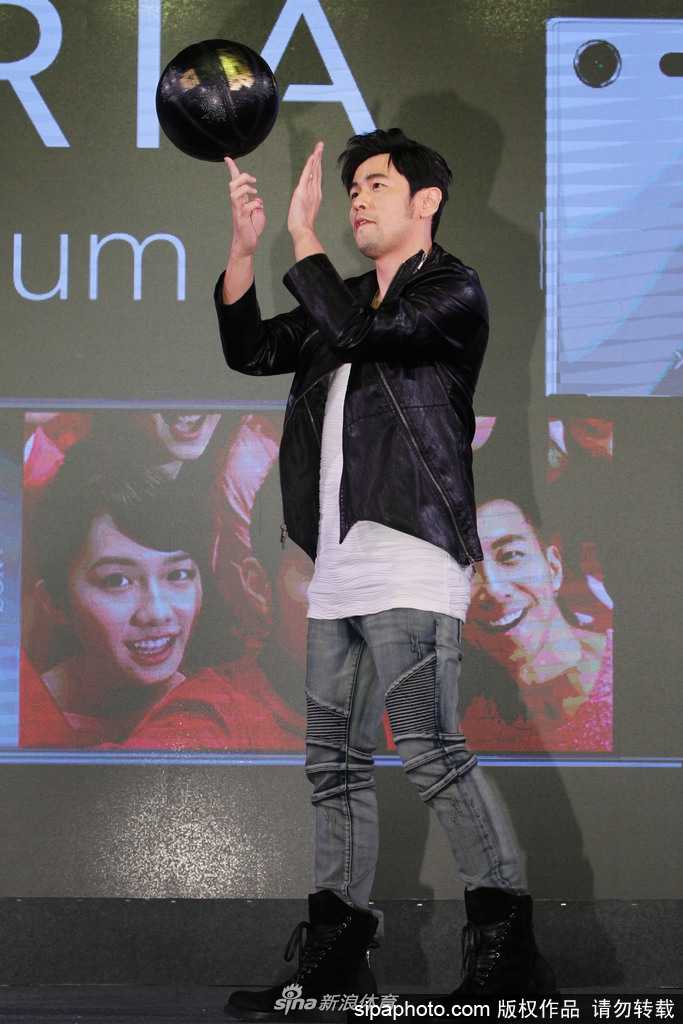 周杰伦高高跃起，做出投篮动作，尽管是在活动场地上，他依然投入地享受着篮球带来的快乐。