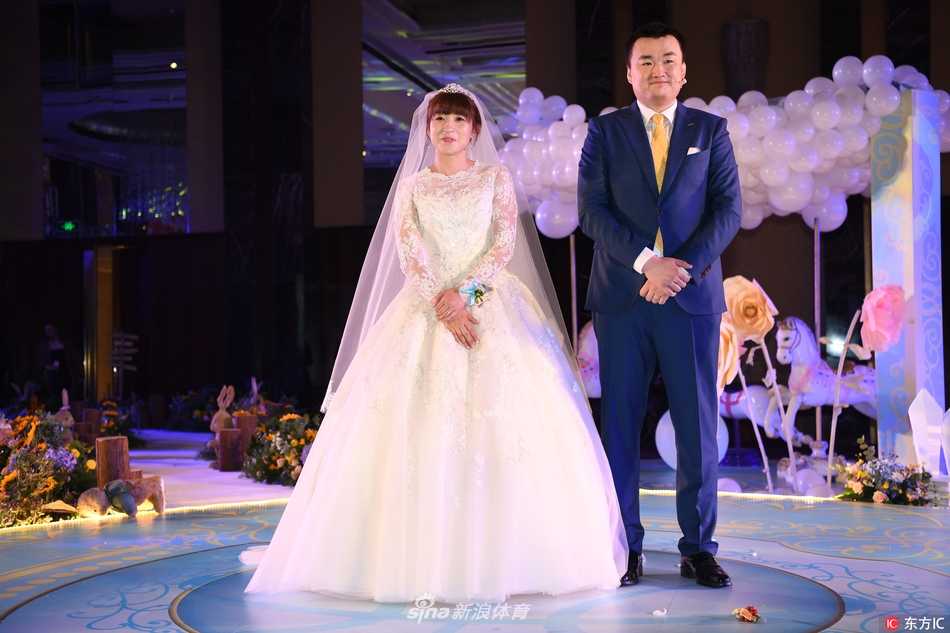 女篮名将杨半伴大婚:从球场“变速器”到人生新赛场 杨半伴与亲友们在婚礼上合影留念,她手举大红包,笑容灿烂,背景是喜庆的红色中式装饰。