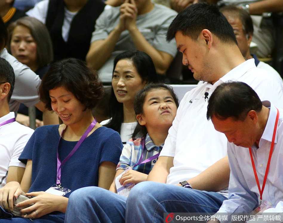 中国球员周琦在第三节与小球员同场竞技时高高跃起，隔着防守的小球员完成一记单手灌篮，落地后微笑着与身边的小朋友击掌