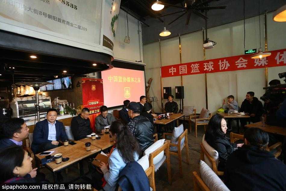 篮球巨人姚明在媒体之家活动中露出标志性的笑容，他手中握着一份文件，仿佛正与在场的记者朋友们轻松叙旧，气氛十分融洽。