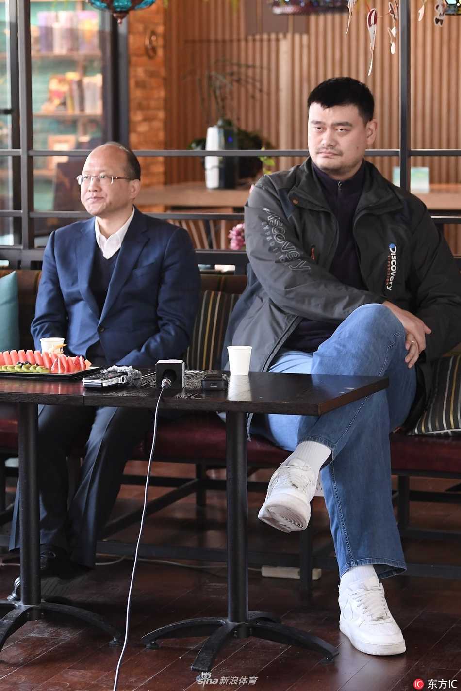 姚明携裁判直面争议 详解CBA联赛执法风云 姚明身着深色休闲卫衣,双手插兜站在台侧,神情专注地聆听身旁裁判讲解技术录像,目光深邃而平和。