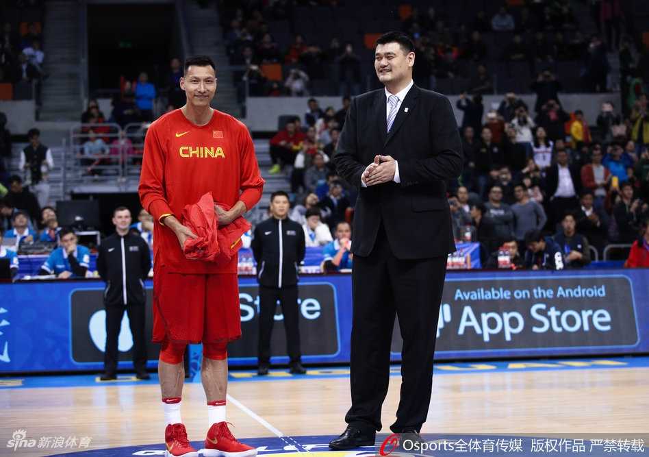 姚明与易建联在场上并肩而立，两人的身影在灯光下被拉长，姚明侧身对着阿联叮嘱着什么，阿联认真倾听，画面里仿佛流淌着中国男篮两大内线传承的温情与厚重。