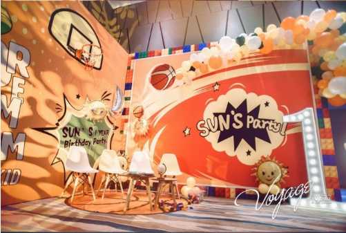 孙悦与陈露为爱子举办篮球主题周岁宴 一家四口温馨有爱 孙悦陈露夫妇与亲朋好友在生日背景板前的大合影,每个人都手拿篮球气球,现场气氛热烈而欢乐。