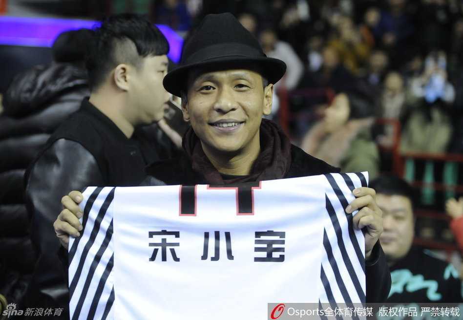 宋小宝化身辽篮吉祥物,身披14号战袍为“兄弟”哈德森呐喊助威 宋小宝双手高举哈德森赠送的14号特别版球衣,站在场边向全场球迷炫耀这份特殊的礼物,表情得意又搞笑,成为全场焦点。