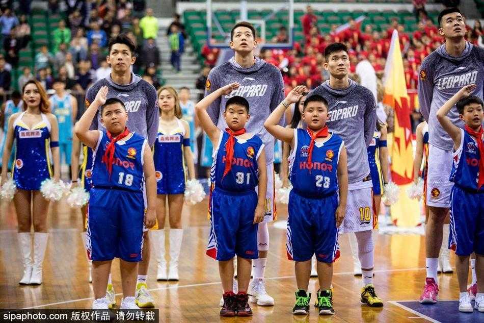 小小少年闯入CBA赛场,专注眼神抢镜成最萌风景线 比赛间隙,一名身穿红色上衣的篮球少年在家长或教练的陪伴下,站在场边背景板前,好奇地打量着这个巨大的赛场,仿佛在丈量自己与梦想之间的距离。