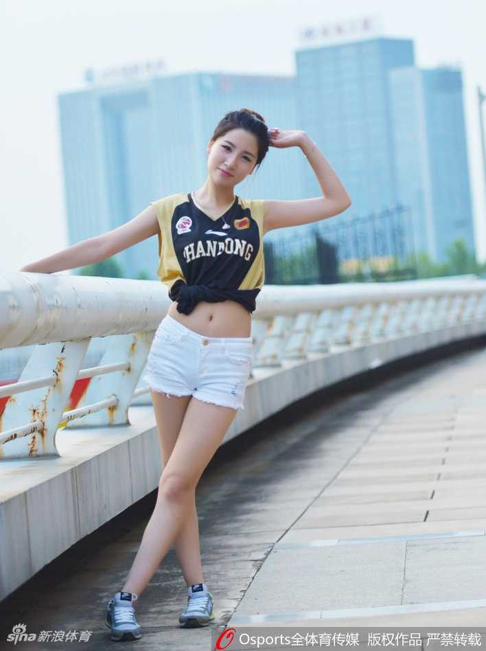 场边最美的风景线，一位山东女球迷身着紧身橙色球衣，搭配白色热裤，她高扎马尾，眼神专注地望向赛场，双手竖起大拇指，用灿烂的笑容为心中的英雄们送上最真挚的赞赏与鼓励。